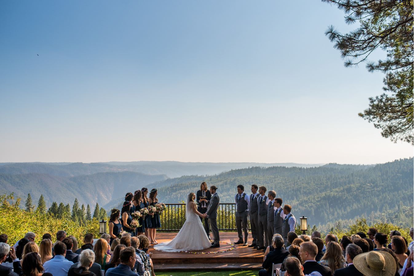 A wedding on a deck with a mountain view in the background.