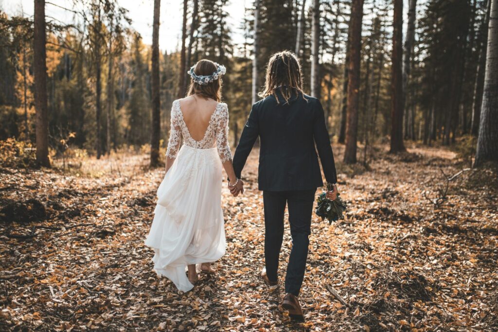 Newlyweds walking through forest.