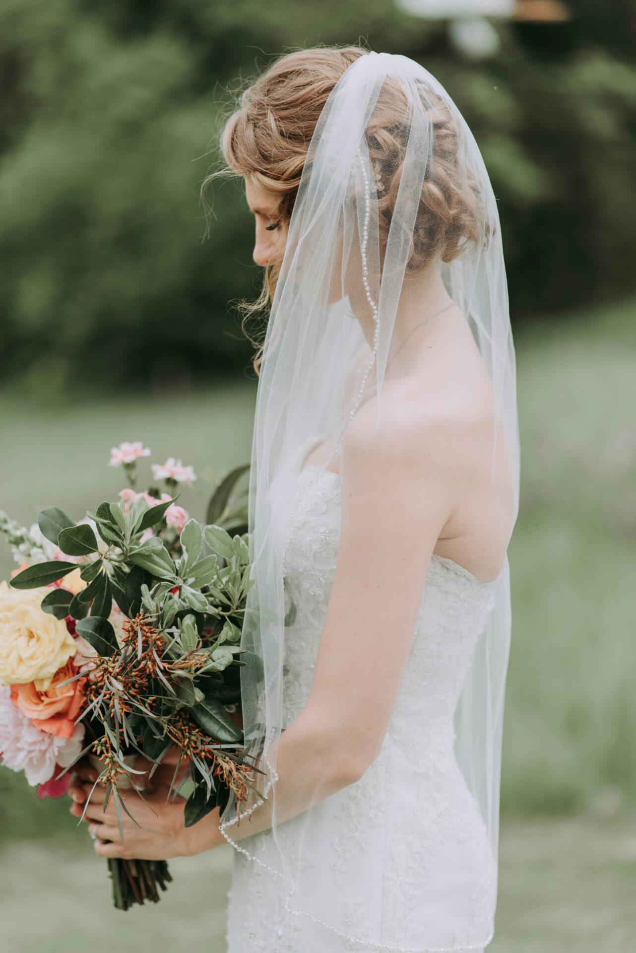 A bride holding a wildflower bouquet.